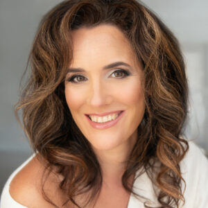 Portrait of Julia Boggio, author, brown hair, brown eyes, white top on light background