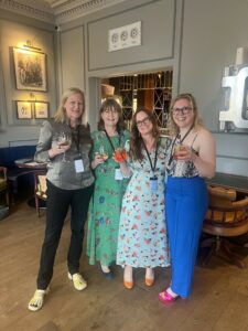 Four women standing together with champagne to celebrate creating the Edinburgh Women's Fiction Festival